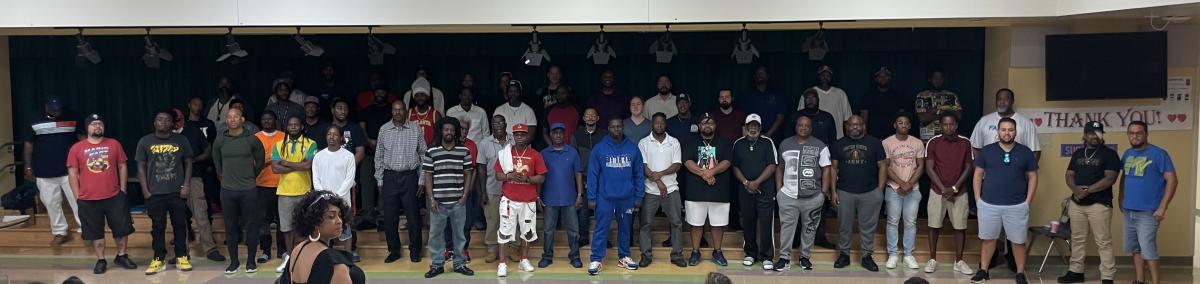 Group of men standing on stage at Hungerford Elementary cafeteria